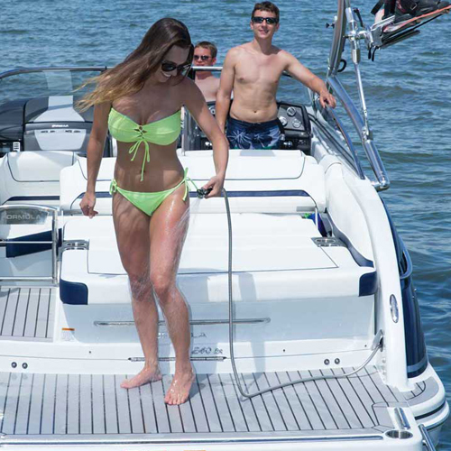 a woman in a bikini is standing on the back of a boat that says formula
