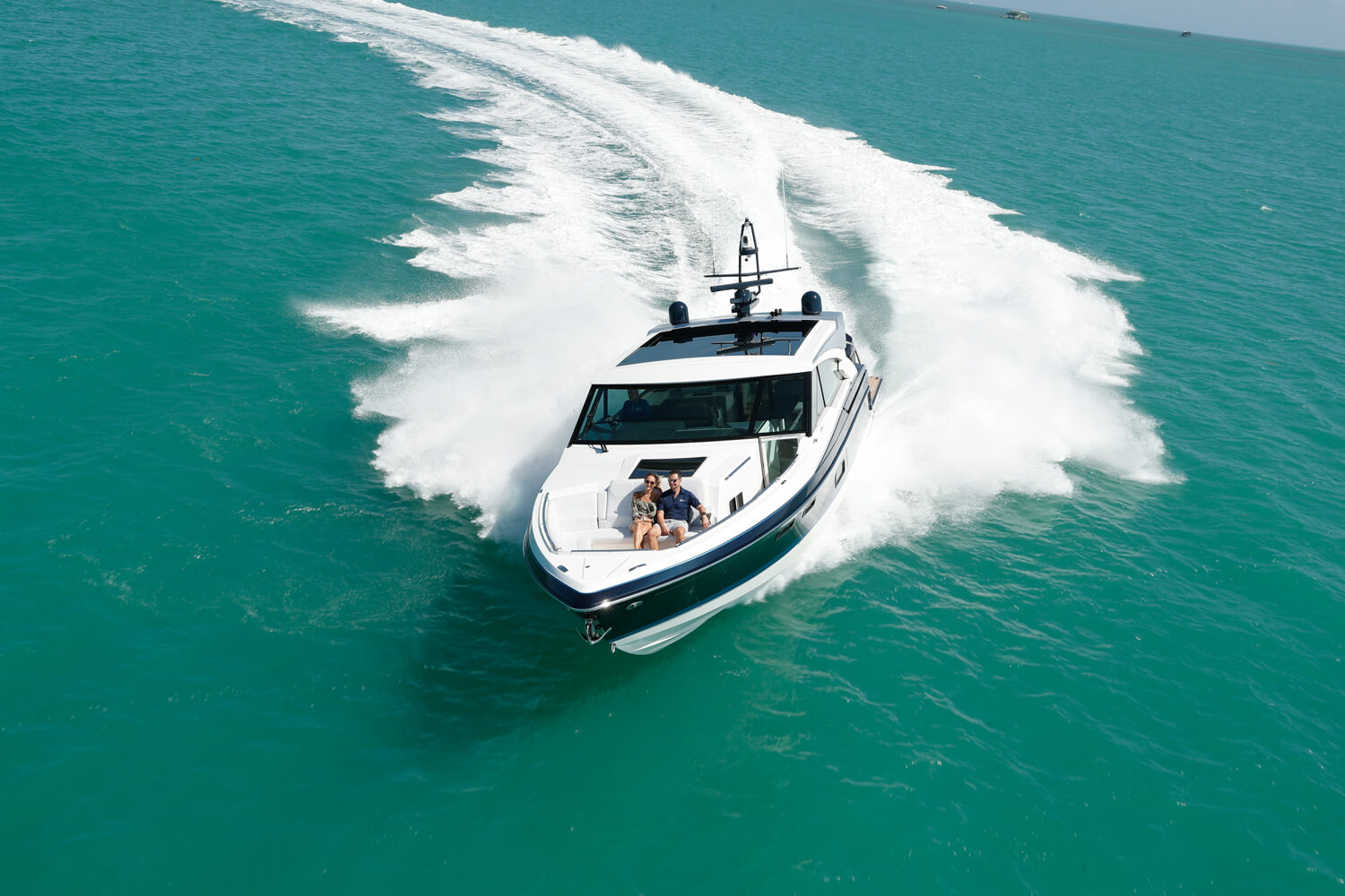 a speed boat is going through the ocean with a few people on it